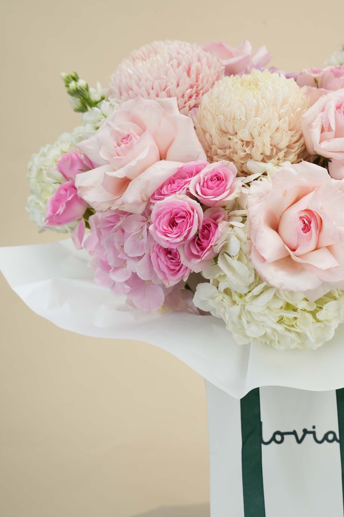 Blush Pink flower bag side view with green handle on table